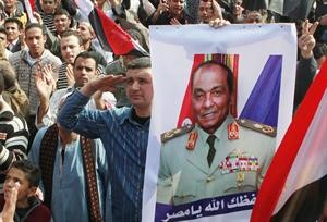 ومتظاهرون يرفعون صورة المشير طنطاوي تاييدا للمجلس العسكري في العباسية امس افپ