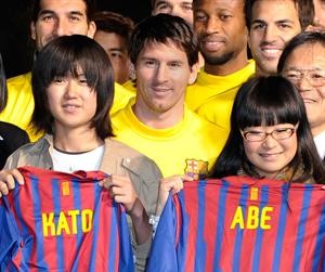 نجم برشلونة ليونيل ميسي وزملاؤه مع الاطفال ضحايا المناطق المنكوبة في اليابان افپ