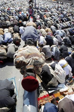جندي منشق عن قوات صالح يؤدي صلاة الجمعة مع المحتجين امس افپ﻿