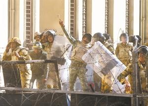 جنود من الجيش يبادلون المحتجين القاء الحجارة بالقرب من ميدان التحرير امس	اپ﻿