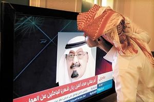 سعودي يقبل صورة الملك عبدالله بن عبدالعزيز بعد المكرمة الملكية التي وهبها للشعب السعودي
