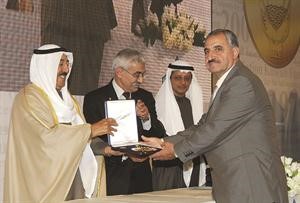 احد الفائزين يتسلم جائزته من صاحب السمو