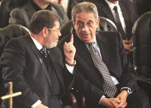 عمرو موسى ومحمد المرسي رئيس حزب الحرية والعدالة يتحدثان خلال الاحتفال