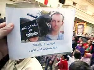 صورة عن الانترنت لمتظاهرين يحملون صورة الصحافي الفرنسي القتيل جيل جاكييه في بلدة الدرباسية في الحسكة	افپ﻿