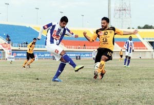 مدافع الجهراء بدر ناصر يبعد الكرة امام لاعب القادسية عبدالعزيز المشعان 	سعود سالم﻿