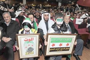 طفلان يحملان لوحتين احداهما شكر للكويت والثانية الموت ولا المذلة﻿