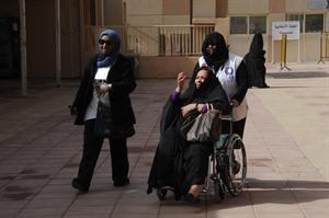  ومتطوعة في الهلال الاحمر تساعد احدى الناخبات