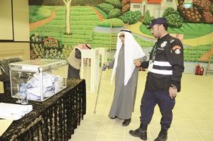 احد رجال الامن يساعد ناخبا من كبار السن

