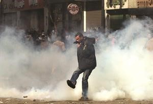 المتظاهرون يحاولون تجنب قنابل الغاز امام وزارة الدخلية امس