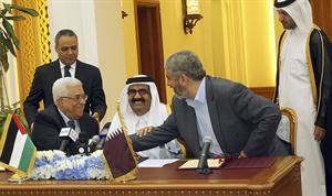 امير قطر الشيخ حمد بن خليفة متوسطا الرئيس الفلسطيني محمود عباس ورئيس المكتب السياسي لحركة حماس خالد مشعل خلال توقيعهما اتفاق المصالحة في الدوحة امس رويترز