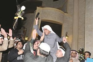 النائب السابق د حسن جوهر محمولا على الاكتاف يرفع عقاله لتحية المحتشدين امام منزله حيث اهدي 10 الاف وردة من نواب ومواطنين	متين غوزال﻿