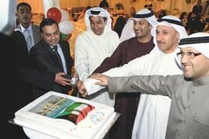 طارق الحمد وصلاح الحداد وعدد من الحضور يقطعون كعكة الاحتفال
