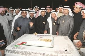 احمد العدساني ونجله النائب رياض العدساني وبعض الحضور يقطعون الكيكة خلال حفل استقبال اقامه على شرف ناخبي الدائرة الثانية هاني الشمري