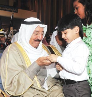 صاحب السمو الامير مداعبا احد الاطفال المشاركين