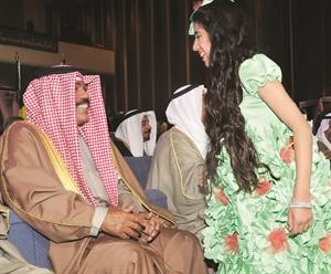 سمو ولي العهد الشيخ نواف الاحمد مداعبا احدى الزهرات