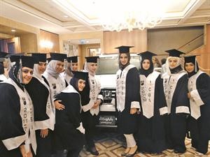 عدد من الطالبات الخريجات في لقطة تذكارية الى جانب سيارة هوندا
