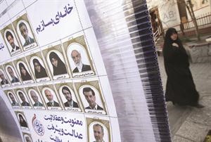 ايرانية تمر بالقرب من ملصقات دعائية للانتخابات التشريعية وسط طهران امس رويترز