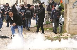 فلسطينيون يحاولون تجنب الغاز المسيل للدموع خلال المواجهات في قرية كفر قدوم افپ