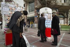 ايرانيون يقراون ملصقات دعائية للانتخابات التشريعية في طهران امس 	رويترز﻿