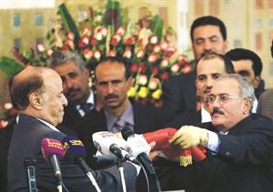 الرئيس اليمني السابق علي عبدالله صالح يسلم العلم اليمني للرئيس الحالي عبدربه منصور هادي خلال مراسم تسليم السلطة في صنعاء امس رويترز