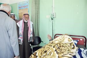 حمود الرومي متفقدا احد المرضى بقطاع غزة
