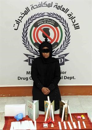 المتهمة وامامها المضبوطات