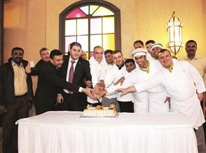 طاقم ميس الغانم سفري يقطعون كيكة الحفل

