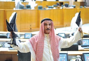 عدنان المطوع رافعا اعلاما سوداء اللون بعد رفع جلسة امس