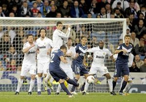 تسديدة لاعب ملقة سانتياغو كازورلا في طريقها لتجاوز الحائط البشري للاعبي ريال مدريد وهز شباك كاسياس افپ

