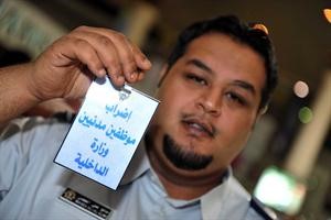 احد مدنيي الداخلية ملوحا ببطاقة الاضراب﻿