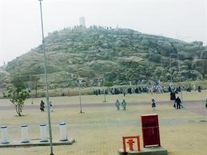زوار يتجمعون حول الشاخص فوق جبل الرحمة بمشعر عرفات