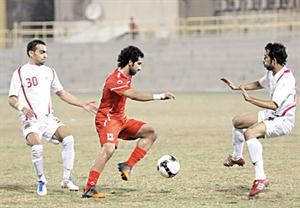 نجم المحرق رينغو يحاول المرور من لاعبي الرفاع الشرقي
