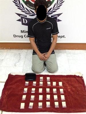 المتهم الاسيوي وامامه المضبوطات﻿