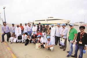 فريق القافلة الاعلامية السياحية في لقطة تذكارية امام احدى العبارتين اللتين تبرع بهما خادم الحرمين الشريفين لسكان فرسان علي السويد
