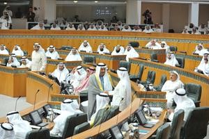 مصافحة بين سمو رئيس الوزراء الشيخ جابر المبارك والنائب صالح عاشور قبل اعتلاء الاثنين المنصة لبدء الاستجواب ويبدو النواب والوزراء يراقبون الموقف﻿