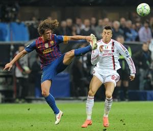 مدافع برشلونة كارليس بويول يبعد الكرة من امام مهاجم ميلان ستيفان الشعراوي افپ