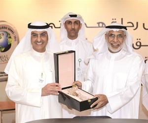 الجلال الى اليسار يقدم هدية تذكارية لنائب مدير الجامعة﻿