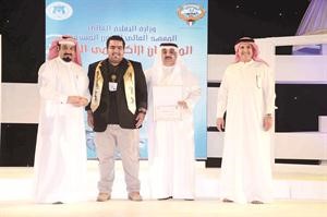 عبد الله النصار يتوسط عميد المعهد ووالده بعد فوزه بجائزة افضل اضاءة﻿