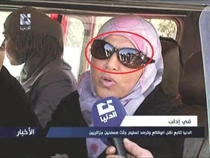 انعكاس صورة رجال الامن والشبيحة على نظارة السيدة﻿