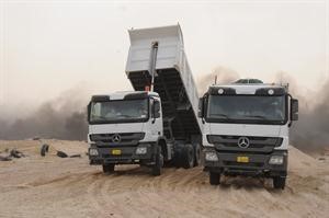 الشاحنات تفرغ حمولات من الرمال بجوار موقع الحريق﻿