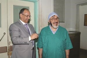 د احمد شفيق يساعد الزميل يوسف عبدالرحمن في ارتداء لباس التعقيم﻿