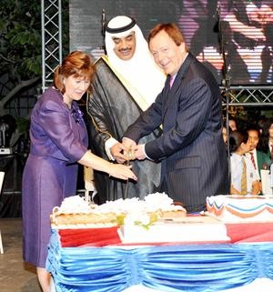  ومشاركا السفير فرانك بيكر قطع كعكة الاحتفال﻿