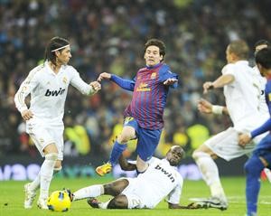 نجم برشلونة ليونيل ميسي محاصرا وسط كتيبة من مدافعي ريال مدريد افپ