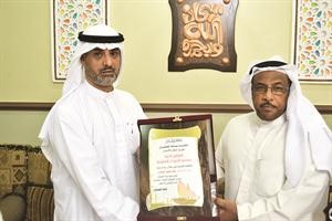خالد الطريجي مكرما العضو الراحل خالد الحوشان ويسلم التكريم لاخيه جاسم الحوشان
