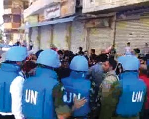 صورة بثها ناشطون على الانترنت لبعثة المراقبين خلال زيارتهم لحي جورة الشياح في حمص