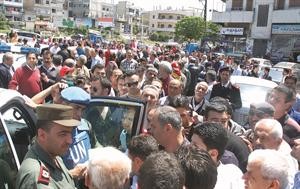 المراقبون الدوليون خلال زيارتهم احد الاحياء الموالية في مدينة حمص رويترز