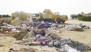 معدات البلدية تزيل المخلفات في المناطق السكنية
