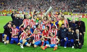 لاعب اتلتيكو مدريد دييغو يحمل الكاس وسط زملاءه افپ