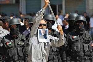متظاهر موال للحكومة الاردنية يرفع صورة للملك عبدالله الثاني خلال تظاهرة في عمان
