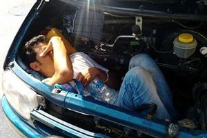 الافغاني نائما بجوار محرك سيارته